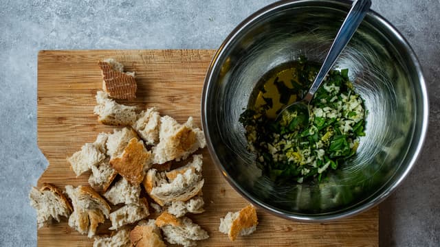 Riv brødet i store biter. Finhakk hvitløk og basilikum og riv sitronskallet før du presser sitronen. Bland brødet med blandingen.