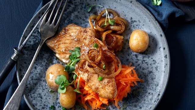 Fordel løken over fisken. Mens dette koser seg i pannen, river du gulrøttene og skviser over sitronsaft. Server sei med løk, nykokte poteter, finkuttet gressløk og smeltet smør.