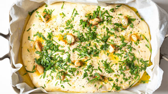 Smelt smøret i en kjele. Ha i persille, finhakkede hvitløksfedd, salt og pepper. Stikk de marinerte hvitløksfeddene ned i deigen og pensle med hvitløksmøret.