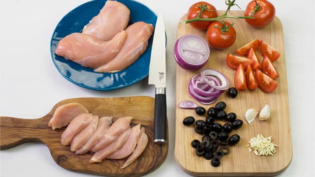 Skjær kyllingfilet, løk, oliven, hvitløk og tomater i skiver og fordel med litt olivenolje på fire stykker bakepapir.
