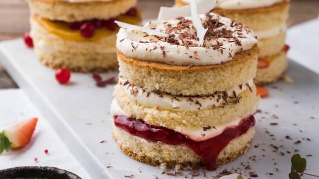 Pisk kremfløten. Fyll kakene med vaniljekrem, krem og bær.