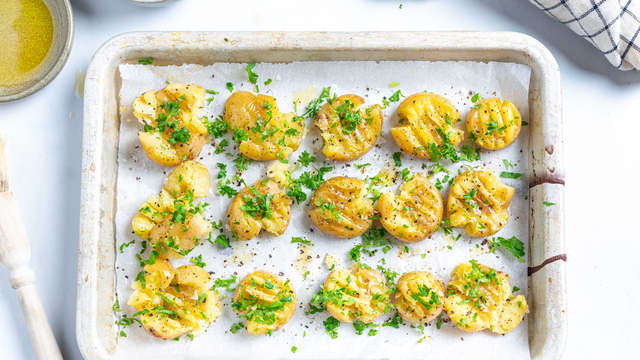 Pensle de knuste potetene med olje og krydre de med salt, pepper og urter.