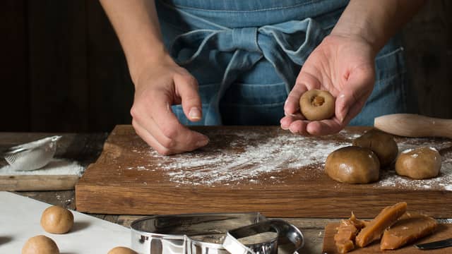 Form pepperkakedeig til kuler (her kan man også lage firkanter), lag deretter et lite hull som du fyller med karamell. Lukk deigen over karamellen slik at den ikke flyter ut.