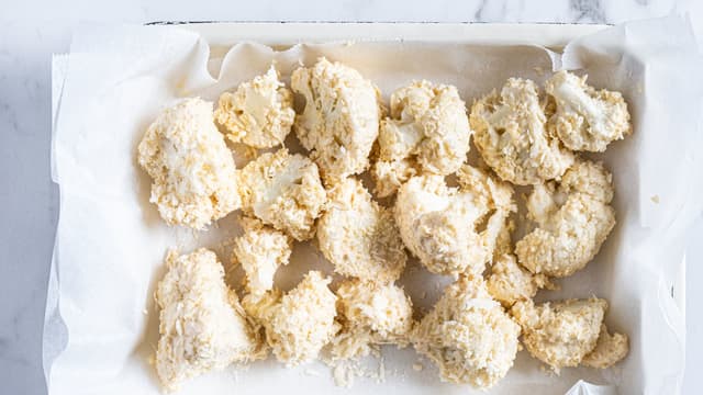 Legg blomkålbukettene på et bakebrett med bakepapir og stek dem midt i ovnen på 200 grader i ca 30 minutter til de er møre og gylne.