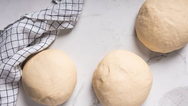 Elt deigen mellom hendene, lag fine små boller og legg dem på et oljet bakebrett med god avstand mellom hver. La deigballene stå på brettet i å etterheve noe. Dryss på litt mel og press brødene ut til flate og fine pitabrød.