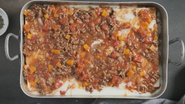 **Lasagne:** Legg kjøttsaus, lasagneplater og ostesaus lagvis i en ildfast form. Topp med revet ost.