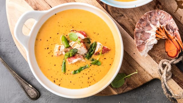 Smak suppen til med krydder, fordel hummerkjøttet i skåler og hell suppen over. Topp med asparges rett før servering.