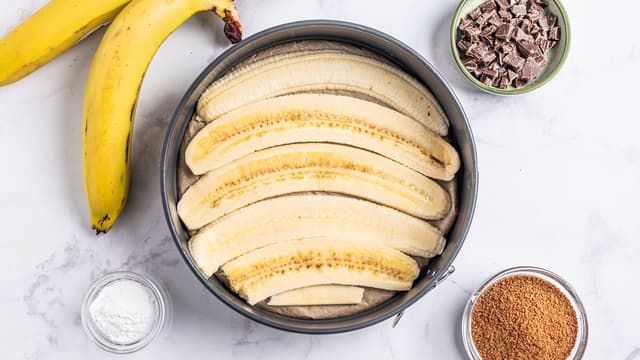 Del 2–3 bananer på langs og legg dem med snittflaten ned i bunnen av formen.