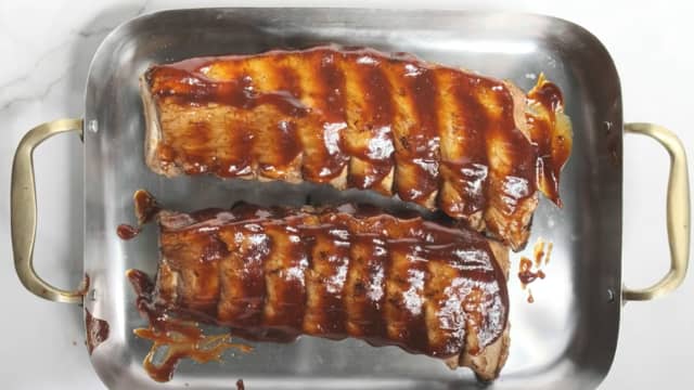 Legg de ferdigkokte spareribsene på et bakebrett og pensle med BBQ saus. Du kan enten steke dem ferdig på 180 grader i 20-30 minutter, midt i ovnen, eller du kan legge dem på indirekte varme på grillen i 20-30 minutter til de er gylne, møre og saftige.