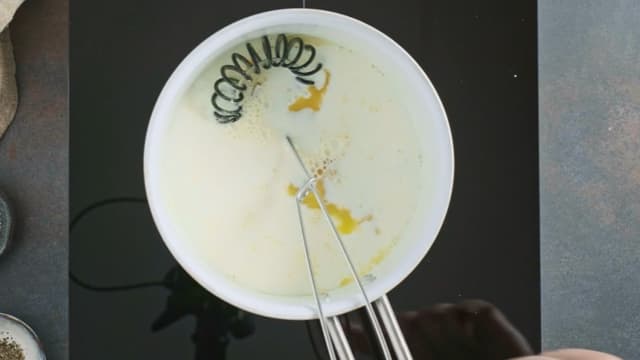 Spe jevningen med varm melk, mens du hele tiden pisker. Når du har tilsatt all melken og det ikke er mer klumper i sausen, gir du sausen et oppkok.