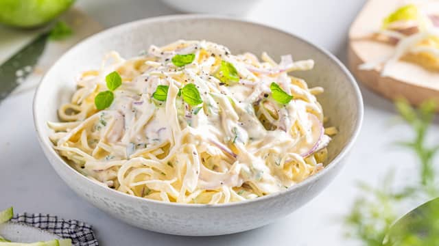 Finsnitt kålen. Kutt eplet i små terninger. Finhakk bladpersille og riv gulrot. Vend dressingen inn med kål, eple, bladpersille og gulrot.