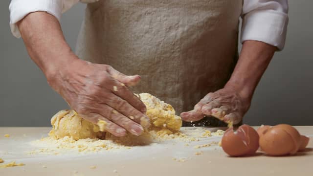 Deretter knar du deigen i ca 5 minutter, til den
blir sammenhengende, myk og smidig. Bruk
hendene. Deigen må ikke føles tørr og om den
klistrer seg til bordet eller hånden, tilsetter du litt
mer hvetemel. Deigen skal være myk og elastisk
og ha "blankt" utseende. Sett deigen til side, og la
den hvile minst 20 minutter før du kjevler den ut
så tynt og jevnt som mulig.