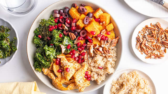 Anrett quinoa, kylling, oliven, pekannøtter og grønnkål i boller eller på tallerkener. Topp gjerne med friske urter!