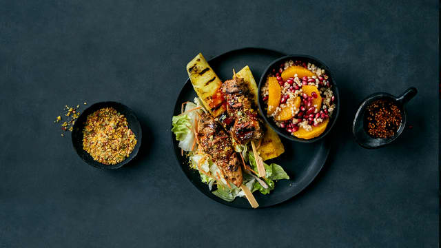 Chili- og appelsinmarinerte svinesticks med byggris og grillet ananas