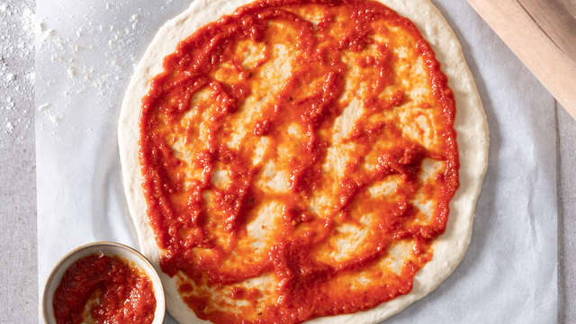 Smør pizzasaus på pizzabunnene