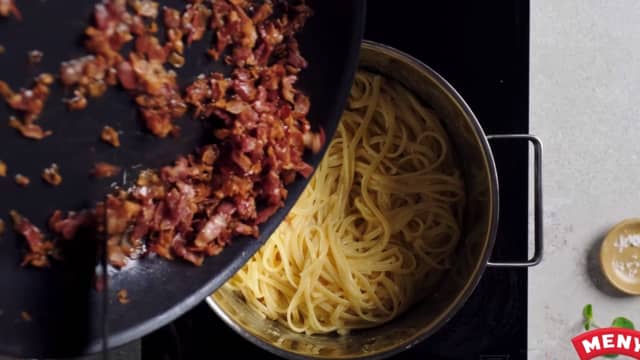 Vend inn sprøstekt bacon og kyllingkjøtt. Smak til med salt og pepper. Ha over revet parmesan og servèr på et fat med bakte tomater, og gjerne en ekstra eggeplomme.