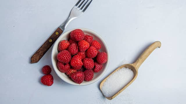 Finn fram bringebær, sukker og en gaffel
