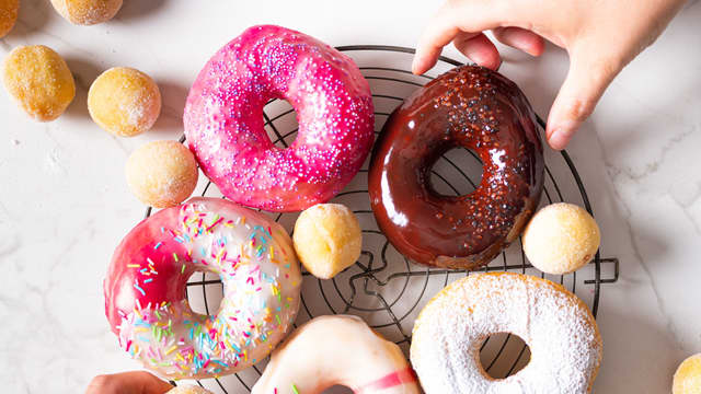 Topp de avkjølte donutsene med melisglasuren.