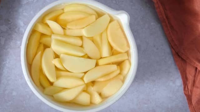 Skrell epler og kutt dem i mellomstore biter. Spar eventuelt to epler til å skjære i fine båter dersom du vil ha mønster på toppen.