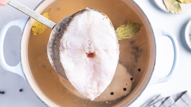 Sett kjelen tilbake på platen og skru ned til laveste temperatur. La fisken få trekke til den akkurat slipper beina. Det tar 10–12 minutter.