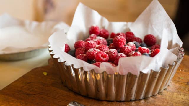 Kle en passende form (som tåler en runde på grillen) med bakepapir og tilsett bærene blandet med sukker og vaniljesukker.