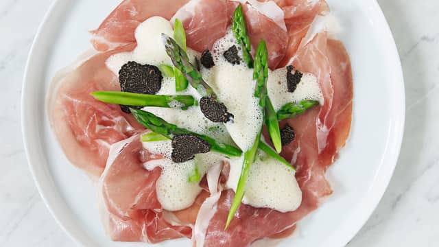 Legg spekeskinken flatt ut på tallerken og legg aspargesen over skinken. Løft skummet over aspargesen og skinken.