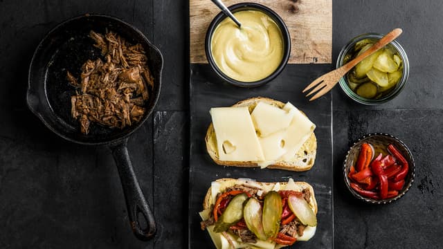 Smør loffskivene med sennep og legg på ost. Legg pulled pork krydret
med spisskummen, sylteagurk og paprika på den ene osteskiven.