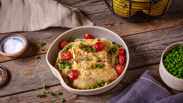 Stek erter, kapers og cherrytomater sammen med piggvaren de siste 2 minuttene. Ha i soyasausen mot slutten av steketiden. Ha pastaen i serveringsboller og topp den med fisk, grønnsaker og saus like før servering.