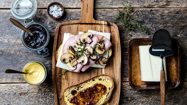 Smør fikenmarmelade og sennep på brødskivene. Legg ost, skinke og sopp på den ene skiven og topp med den andre brødskiven.