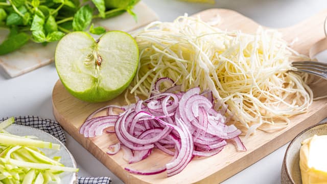 Rens og skjær kålen, epler og rødløk i tynne skiver. Grovhakk mynten.