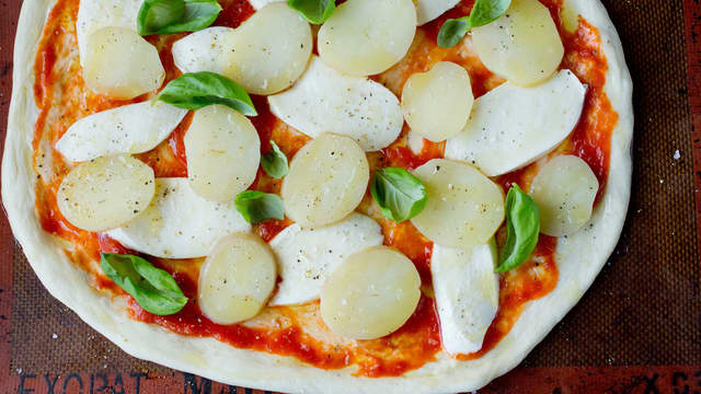 Smør pizzabunnen med et tynt lag tomatsaus. Fordel mozzarella og potetskiver utover bunnen.