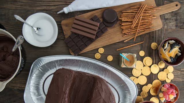 Smør sjokoladeglasur rundt hele kaken og for å feste bitene av kaken til hverandre.