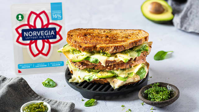 Skrell og del avokado i tynne skiver, fordel på de to skivene. Legg lagvis over spiser, spinat og til slutt ost. Dryss over pepper.