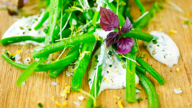 Finhakk sjalottløk og bland sammen med olivenolje. Tilsett 1 ss sitronskall og saften av sitronen. Smak til med flaksalt og pepper. Drypp dressingen over aspargesbønnene eller bland alt sammen.