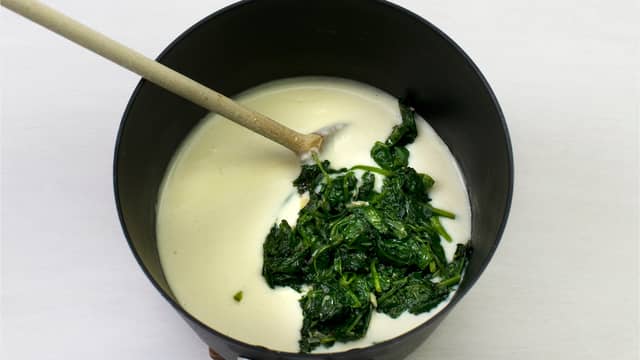 Tilsett muskatnøtt og ost og rør til den har smeltet. Smak til med salt og ha i spinaten.