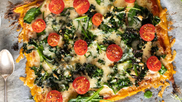 Ta ut pizzaen og topp med tomater før servering.