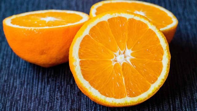 Skrell og riv gulrøttene. Skjær av skallet på appelsinene og skjær ut appelsinfileter. Bland sammen gulrøtter og appelsin.