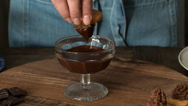 Ta bollen av vannet, tilsett resten av sjokoladen og bland sammen til alt er flytende. Dypp kransekaketoppene i sjokoladen og la tørke.