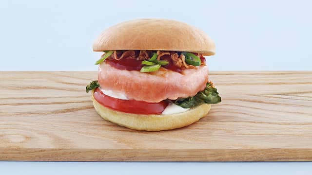 Legg så på lakseburger og pensle med BBQ saus. Topp med mer rømme, snittet vårløk og sprøstekt løk. Topp med burgerbrødet og nyt!