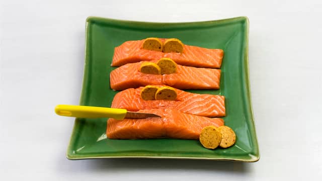 Skjær et snitt i hver lakseporsjon og fyll med kryddersmør.