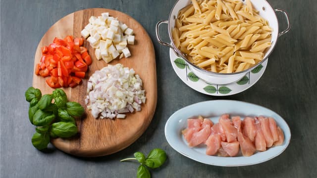 Kok pasta etter anvisning på pakken. Skjær selleri, løk og paprika i små terninger, hakk basilikum og skjær kylling i strimler.