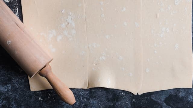 Strø litt mel på kjøkkenbenken. Legg butterdeigplatene på benken. Legg dem slik at de overlapper hverandre litt. 
Kjevle ut platene så de blir ca halvparten så tykke.