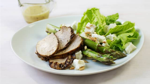 Server nygrillet svinefilet med chevresalaten og grillede asparges.