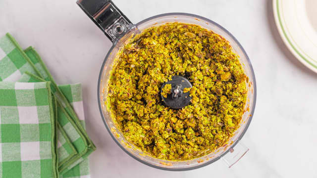 Kjør 200 g av pistasjnøttene i en food prosessor til et fint mel. Grovhakk resten av pistasjnøttene.