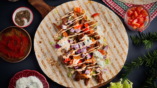 Smør tzatziki på tortillalefsen. Legg på pinnekjøtt, salat, tomat og rødløk. Topp med kebabdressing og rull sammen.