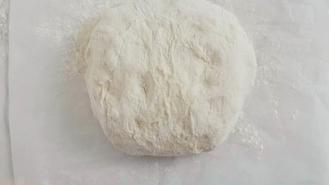 Legg deigen over på et bakepapir med bretteskjøtene ned. Dekk med et kjøkkenhåndkle og la deigen etterheve i 2 timer.