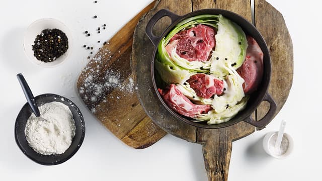 Del kålen i båter, men behold stilken slik at kålen holdes sammen. Skjær løk og persillerot i ca. 2 cm tykke skiver. Start med kjøttet og legg lagvis med kålen i en stor kjele. Strø pepperkorn, salt og de øvrige grønnsakene mellom hvert lag. Strø litt mel mellom lagene hvis du vil ha en jevnet kraft.