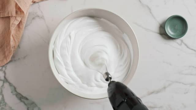 Ha eggehvitene i en bolle og pisk til det skummer. Tilsett melisen og pisk videre til du har en stiv marengs. Vend inn mandlene og bakepulveret.