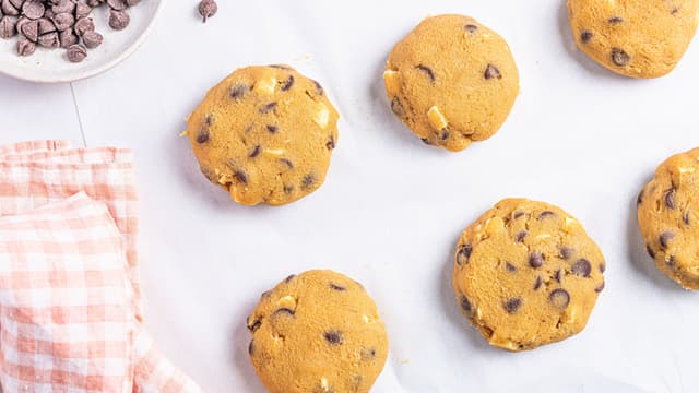 Bruk en teskje for å forme små kuler som du legger utover bakebrettene. Klem lett på dem med baksiden av skjeen så de blir litt flatere.