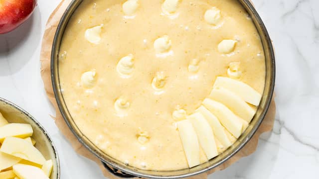 Lag små hull i deigen med en skje og fyll hver grop med ca 1 ss vaniljekrem. Fordel eplebåtene utover og trykk dem litt ned i deigen. Dryss over kanel til slutt.